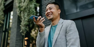 Young Asian man smiling and talking into a cell phone