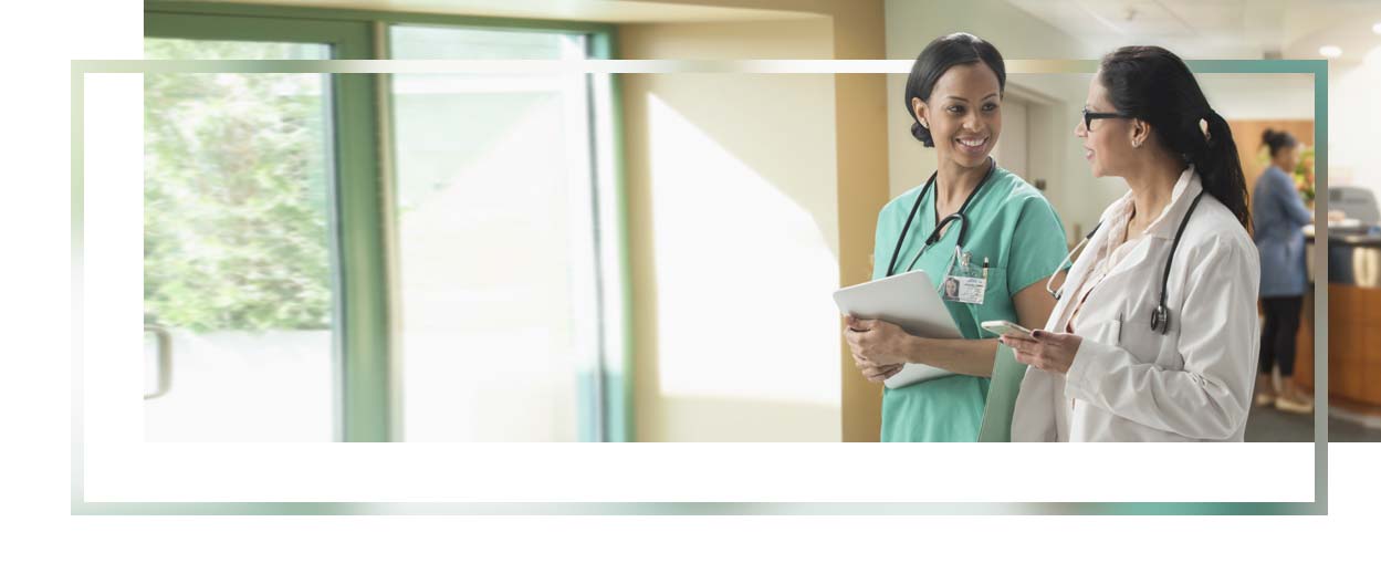 Doctor and nurse talking in hospital hallway