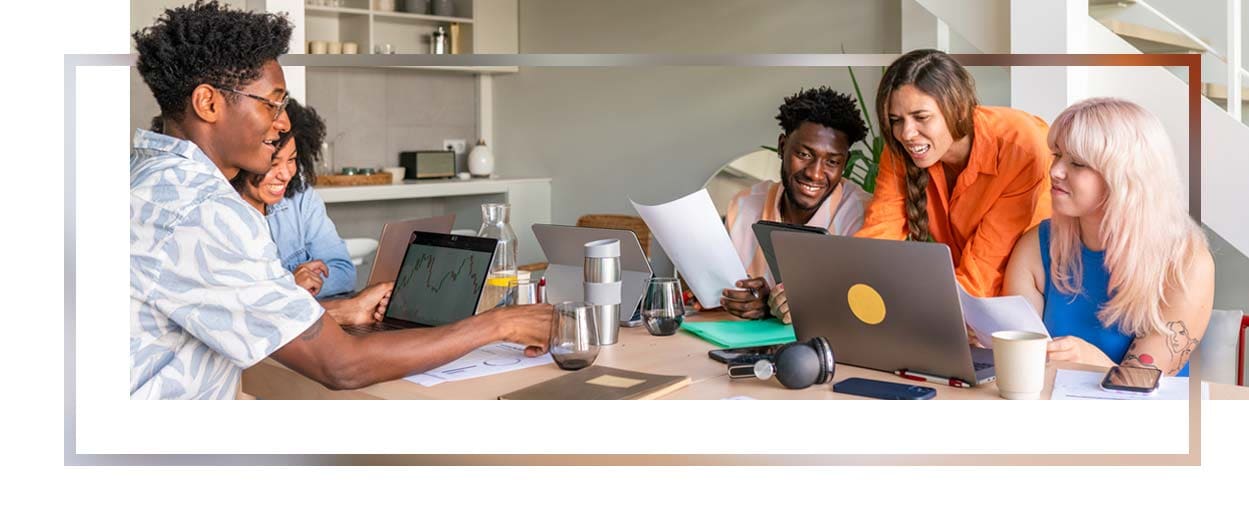 Three colleagues looking at a computer and smiling