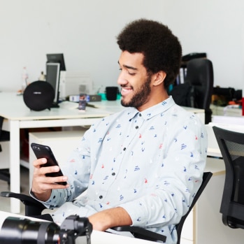 Man sitting in office chair using his mobile phone.