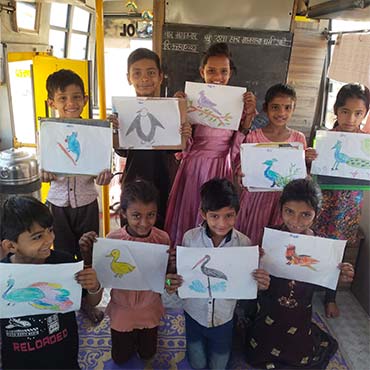 Indian school children holding up drawings they made