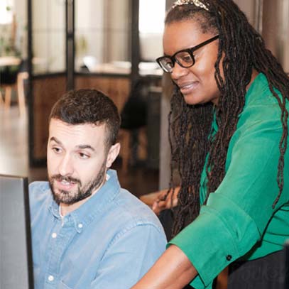 Coworkers looking at a laptop together.