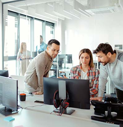 Three people looking at a computer