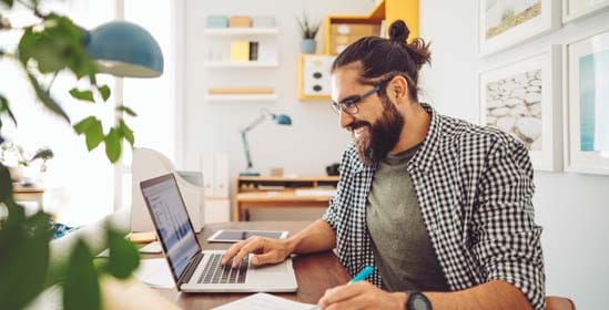 Man sitting at table working on laptop