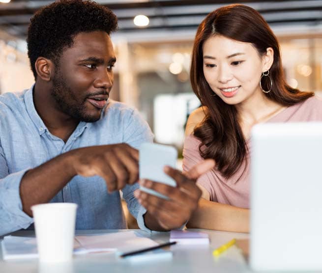 Two coworkers working together with modern technology at office