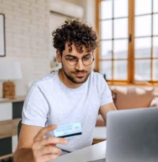 Man online shopping on laptop at home