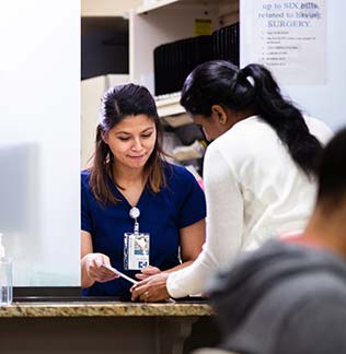 Receptionist helping patient with form