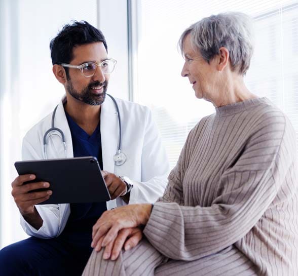 Doctor and patient in conversation, looking at digital tablet