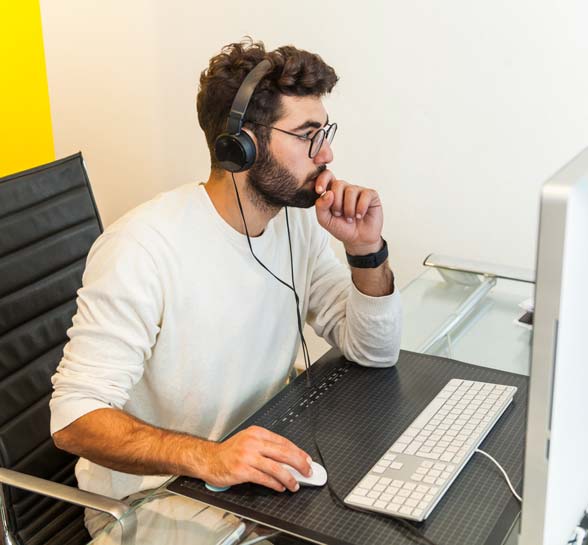 Man working at desk wearing headset.