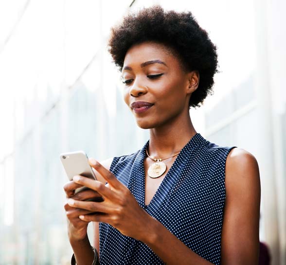 Woman with mobile phone next to building