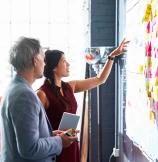 Two work colleagues working on a whiteboardd