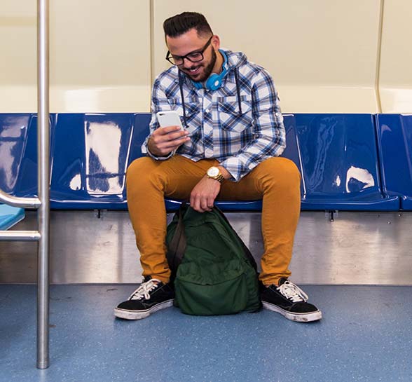 Man on a subway looking at his cellphone 