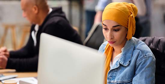 Mujer que trabaja en un estudio de diseño mira la pantalla de su computadora