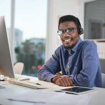 Man using a computer and headset in a modern office