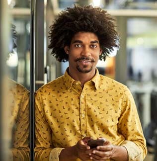 African American businessman with mobile phone in office