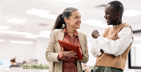 Two women laughing together in an office