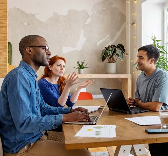 Professionals having a discussion around desk