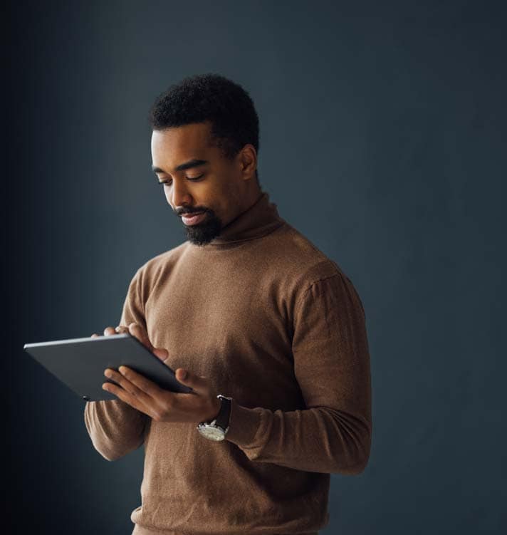 Happy young businessman using tablet in office