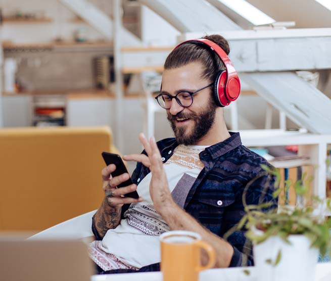 Man with headphones on scrolling though his phone