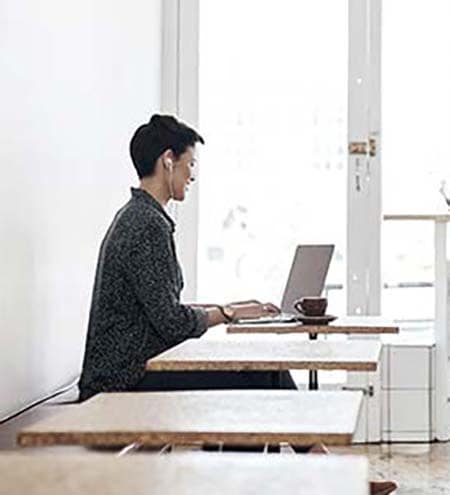 Man and woman on their laptops inside a coffee shop