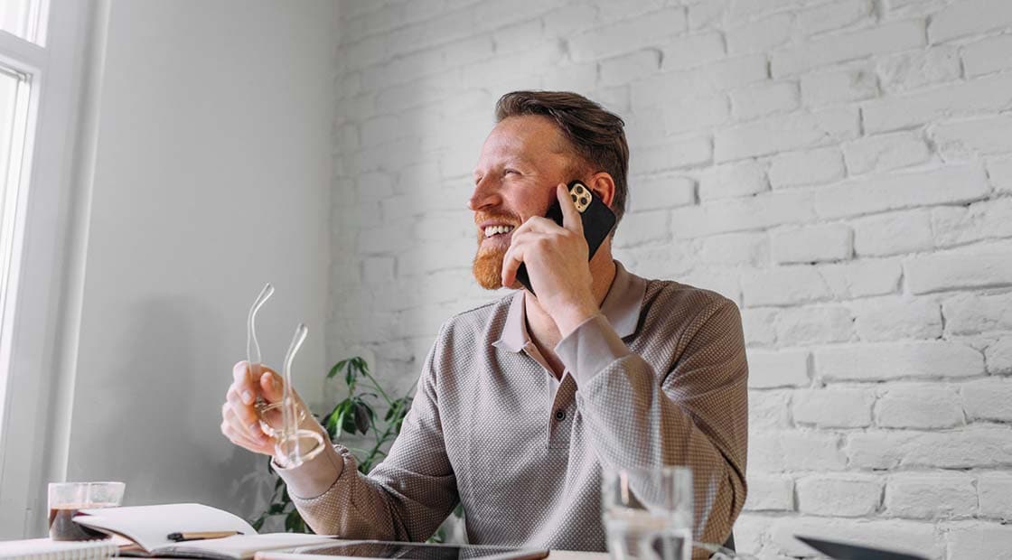 Man holding glasses and talking on the phone 