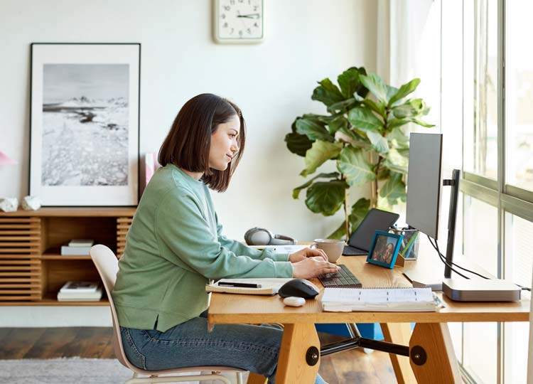 Donna che digita su un laptop, su cui è visibile una conversazione in chat