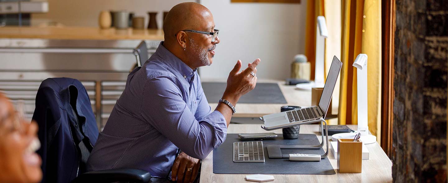 Side view of businessman gesturing while doing video call through laptop at office