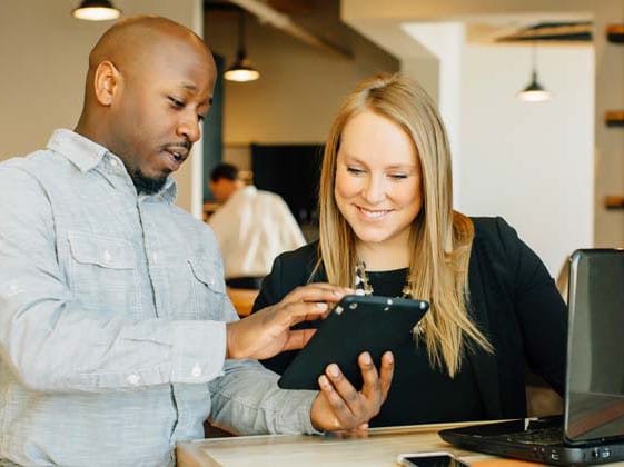 Barista and businesswoman using technology in cafe