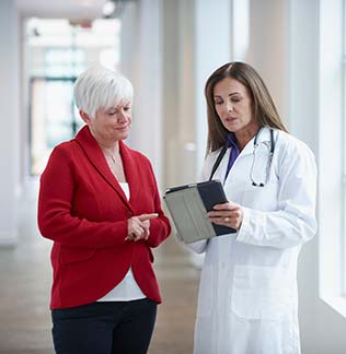 Caucasian doctor and patient talking in hallway