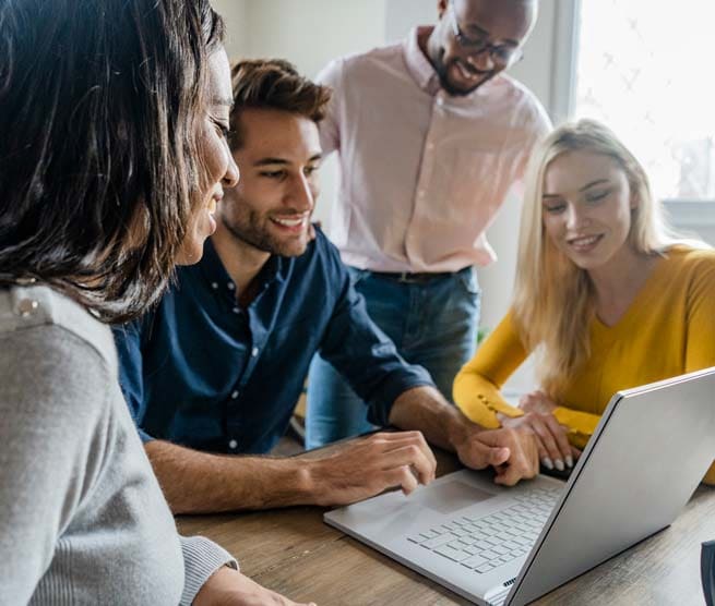 Group of people gathered around a laptop