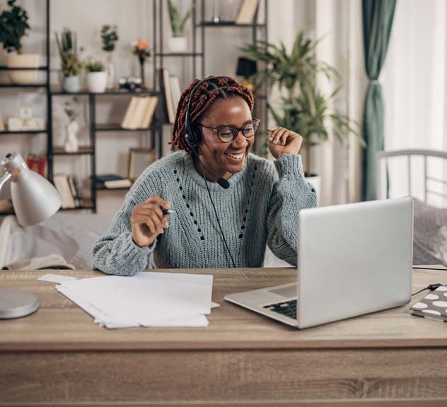 Remote working woman with headset on typing on laptop