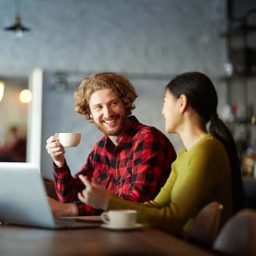 Man and woman sitting in cafe and having talk by cup of tea