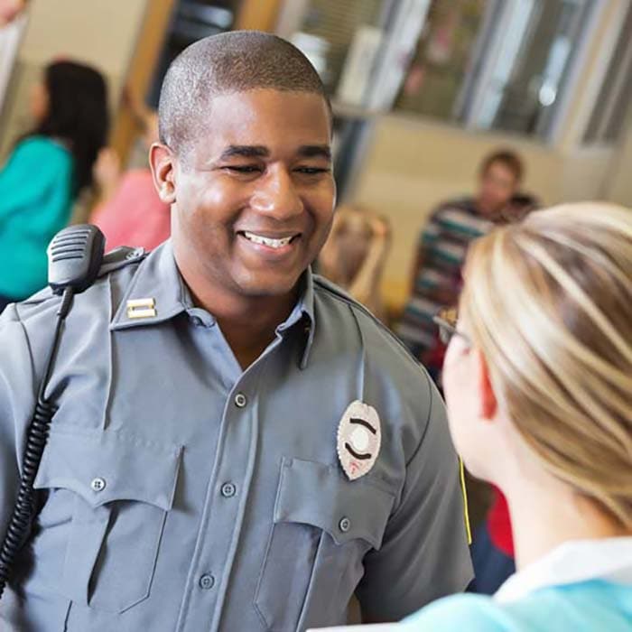 Friendly police officer talking with school teacher