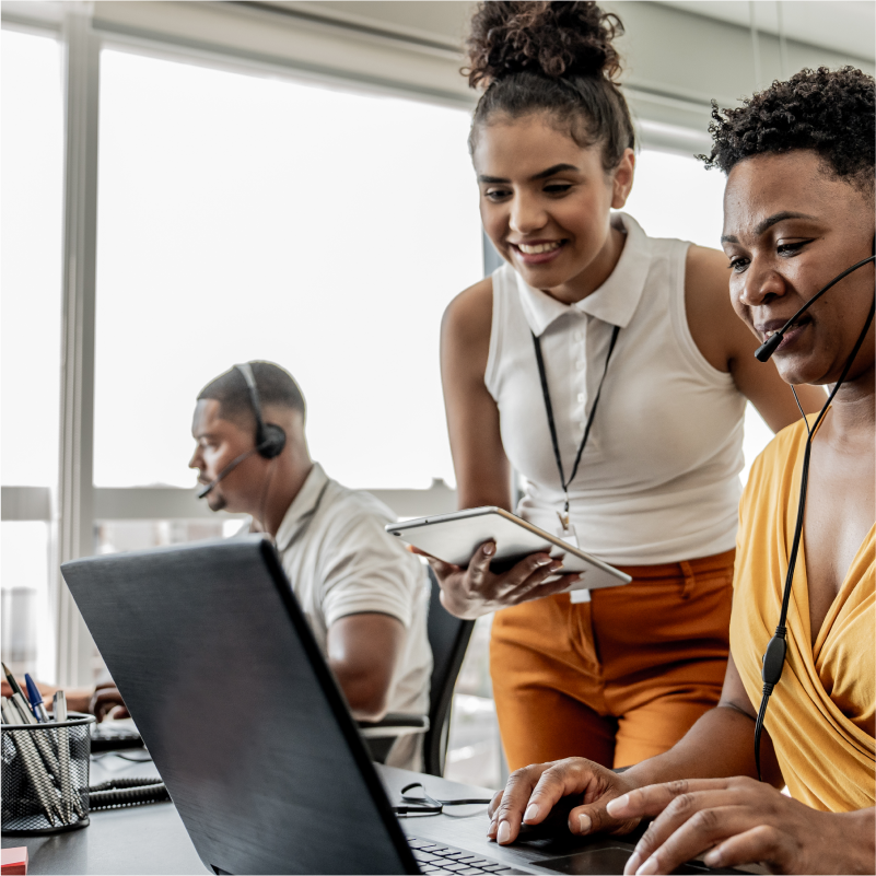 Foto de dos mujeres trabajando de manera conjunta en una pantalla de computadora