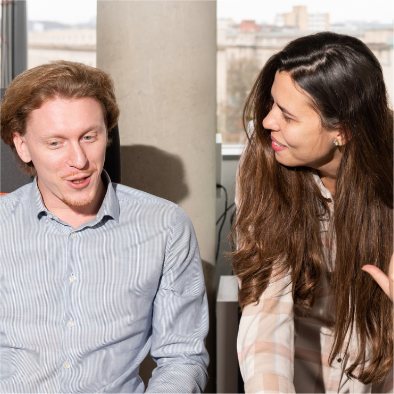 Two co-workers smiling and collaborating in an office