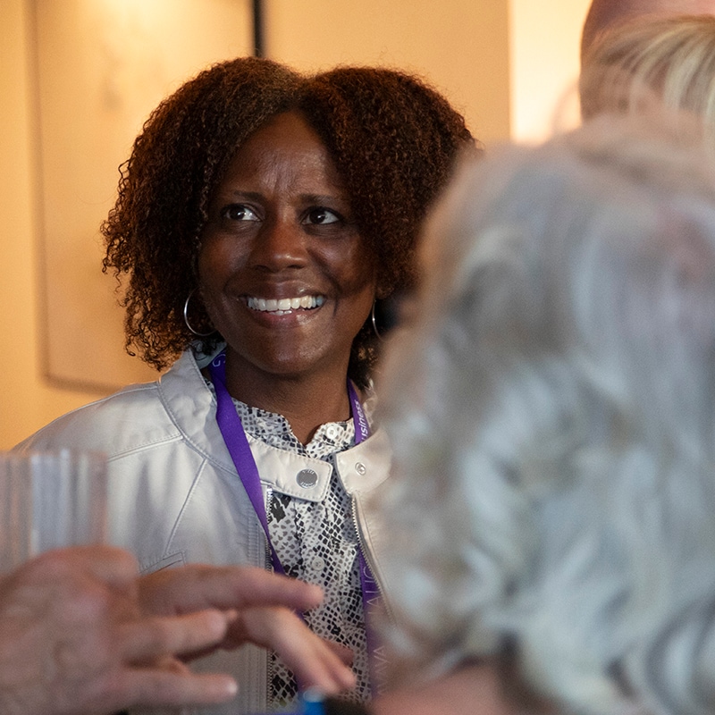 Portrait of a woman smiling wearing a purple lanyard